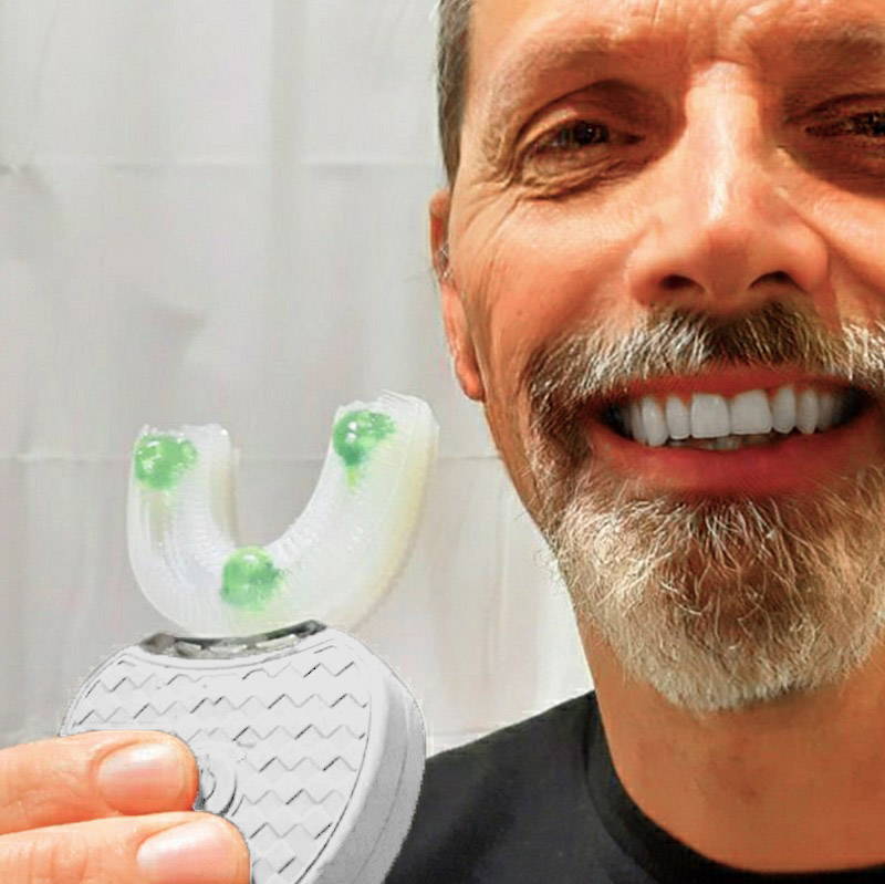 A smiling man holding the UDental Pro toothbrush